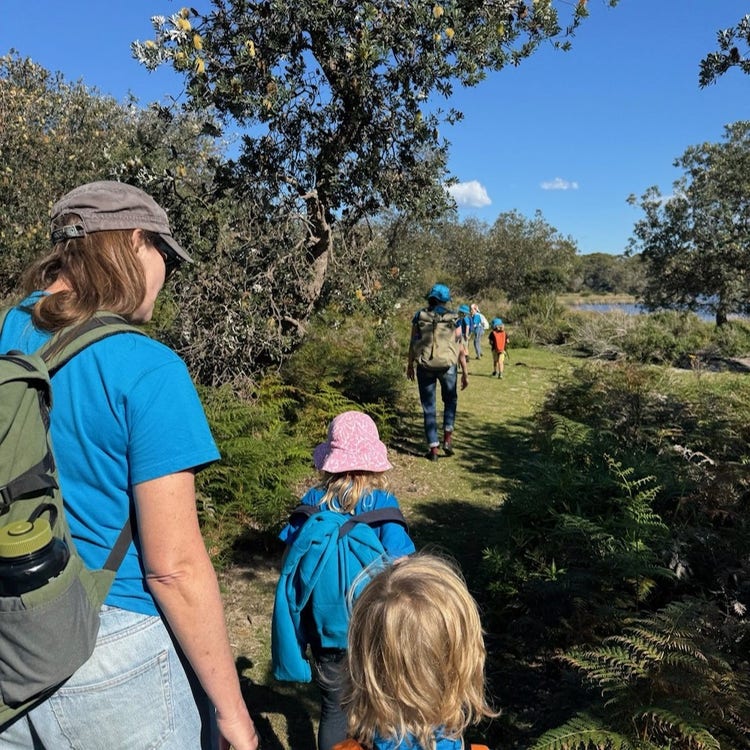 adult and children walk in bush